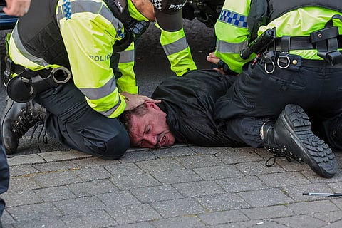 Police officers detain an anti-immigration protester in Blackpool